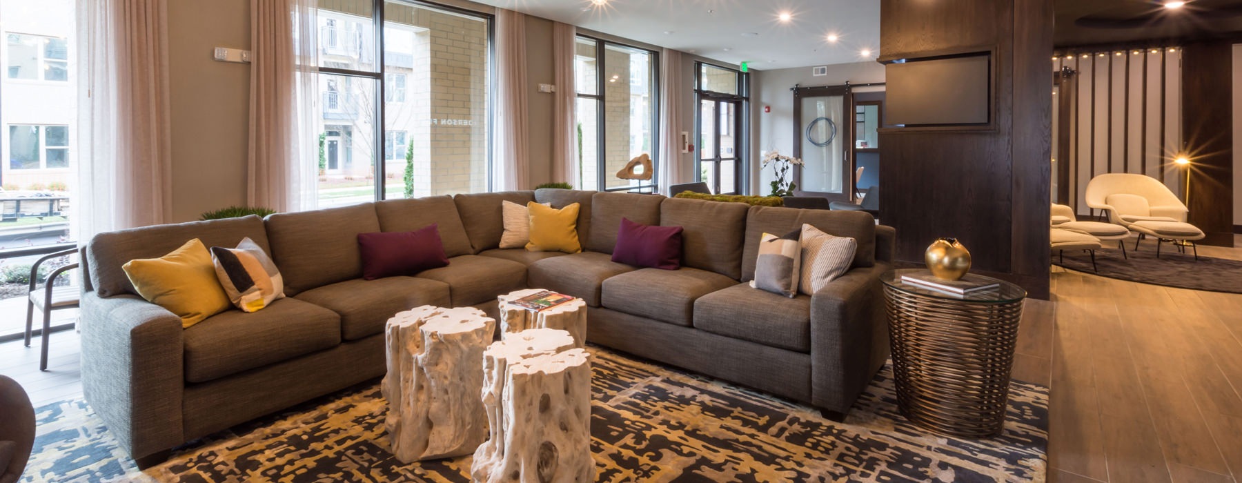 room with large sectional couch with a wall of windows